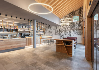 Vista dell’area bar e ristorante della Malga Zambana, con arredi realizzati da Ladin Arredi, fotografia di Elisa Fedrizzi.