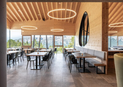 Interno del ristorante della Malga Zambana con tavoli e sedute in legno, foto di Elisa Fedrizzi.
