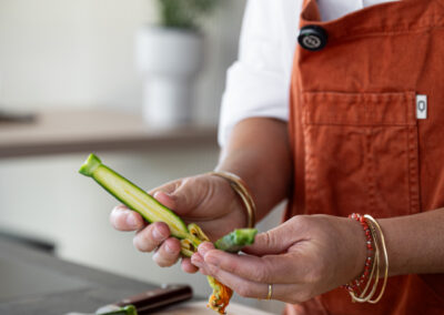 Servizio fotografico food di Elisa Fedrizzi: dettaglio delle mani della food creator mentre prepara le verdure di stagione.