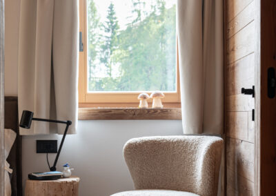 Angolo relax con poltrona e finestra su paesaggio alpino, fotografia d’interni di Elisa Fedrizzi