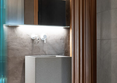 Dettaglio illuminazione bagno moderno, fotografia d’interni sofisticata.