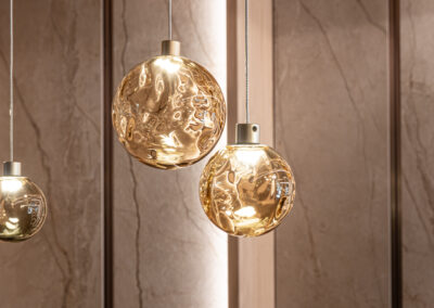 Lampade sospese dorate in hall d’hotel, fotografia d’interni di Elisa Fedrizzi.