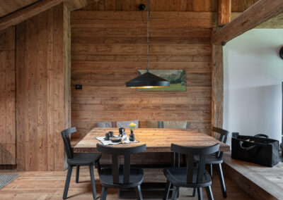 Zona pranzo in legno in stile alpino con luce naturale, fotografia d’interni di Elisa Fedrizzi per Wood & Stone in Val di Fiemme