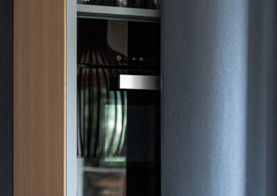 Armadiatura cucina su misura con texture chiare, fotografia architettonica.