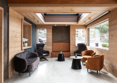 Hall dell’Hotel Paganella di Andalo fotografata da Elisa Fedrizzi, luce naturale e materiali in legno e pietra.