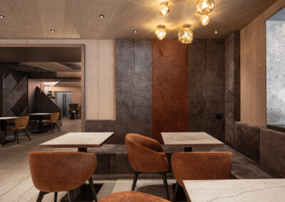 Salottino dell’Hotel Paganella, arredi caldi e texture materiche, fotografia d’interni contemporanea.