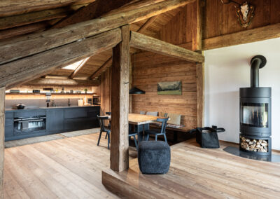 Interno open space con cucina e zona living in legno naturale, fotografia d’interni di Elisa Fedrizzi