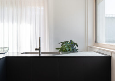 Cucina moderna con isola e tonalità scure a contrasto