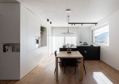 Sala da pranzo moderna con tavolo in legno e arredi essenziali.