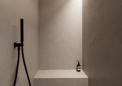 Bagno moderno con giochi di luce e colori neutri.