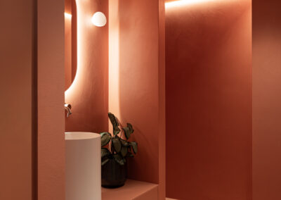 Bagno moderno con specchio retroilluminato e mood caldo.