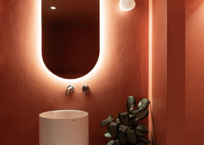 Bagno minimal rosso terracotta con illuminazione di atmosfera.