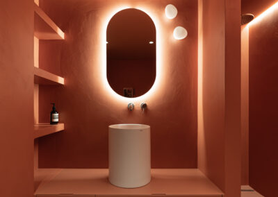 Bagno minimal rosso terracotta con illuminazione di atmosfera.