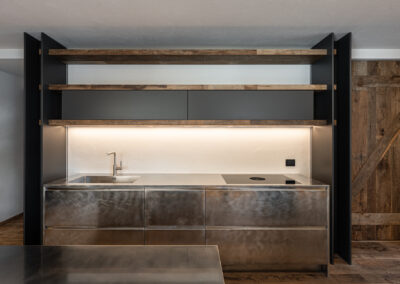 Fotografia di interni realizzata da Elisa Fedrizzi a Madonna di Campiglio: cucina su misura dal design contemporaneo con legno e acciaio.