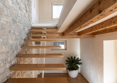 scala in legno con parete in pietra casa ristrutturata