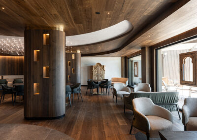 Lounge dell'Hotel Miravalle con arredi in legno e illuminazione calda
